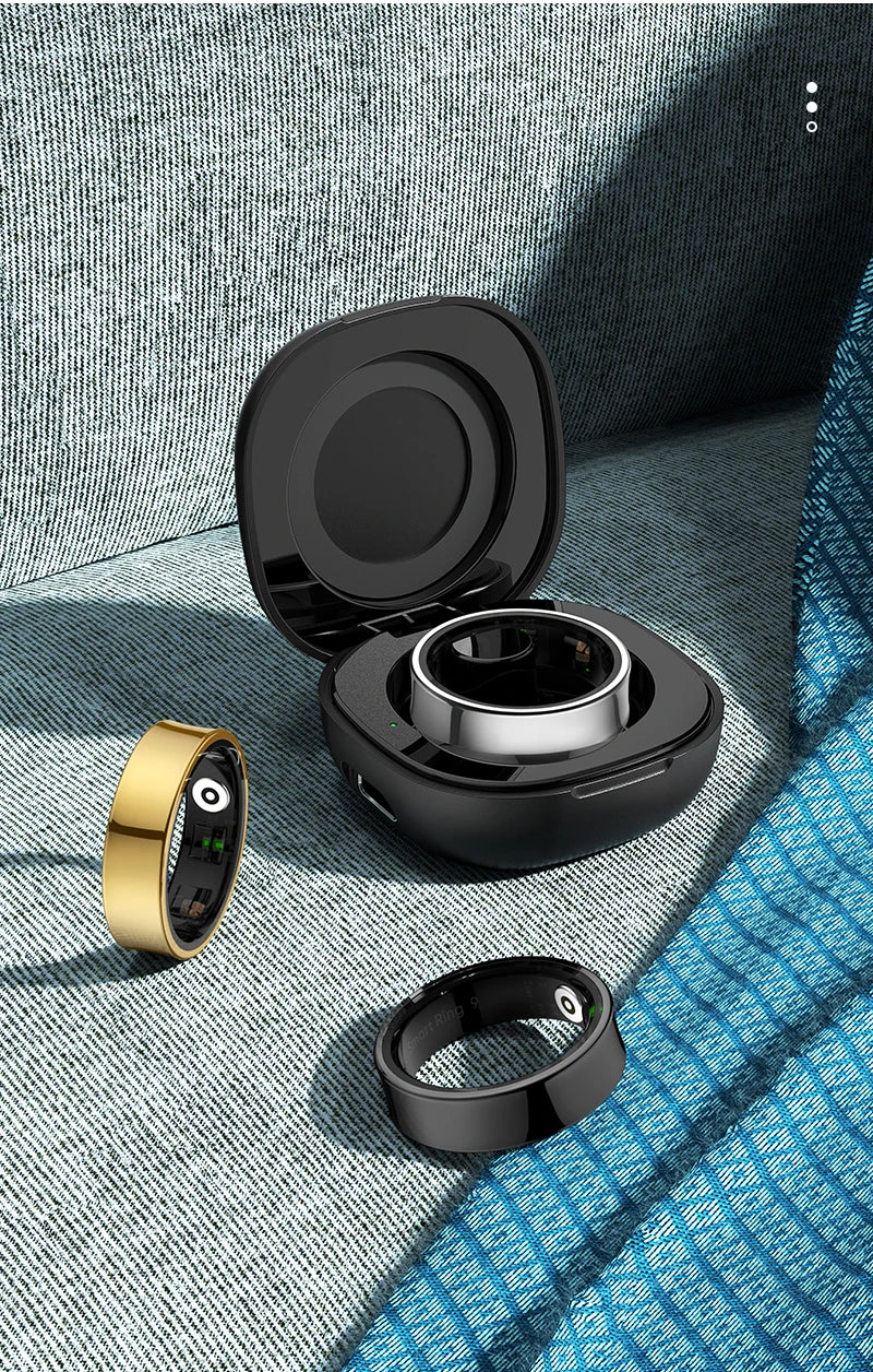 Aura smart ring in gold and black with charging case on textured fabric background