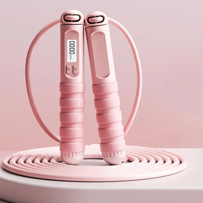 Pink smart jump rope with digital counter and ergonomic handles on light background